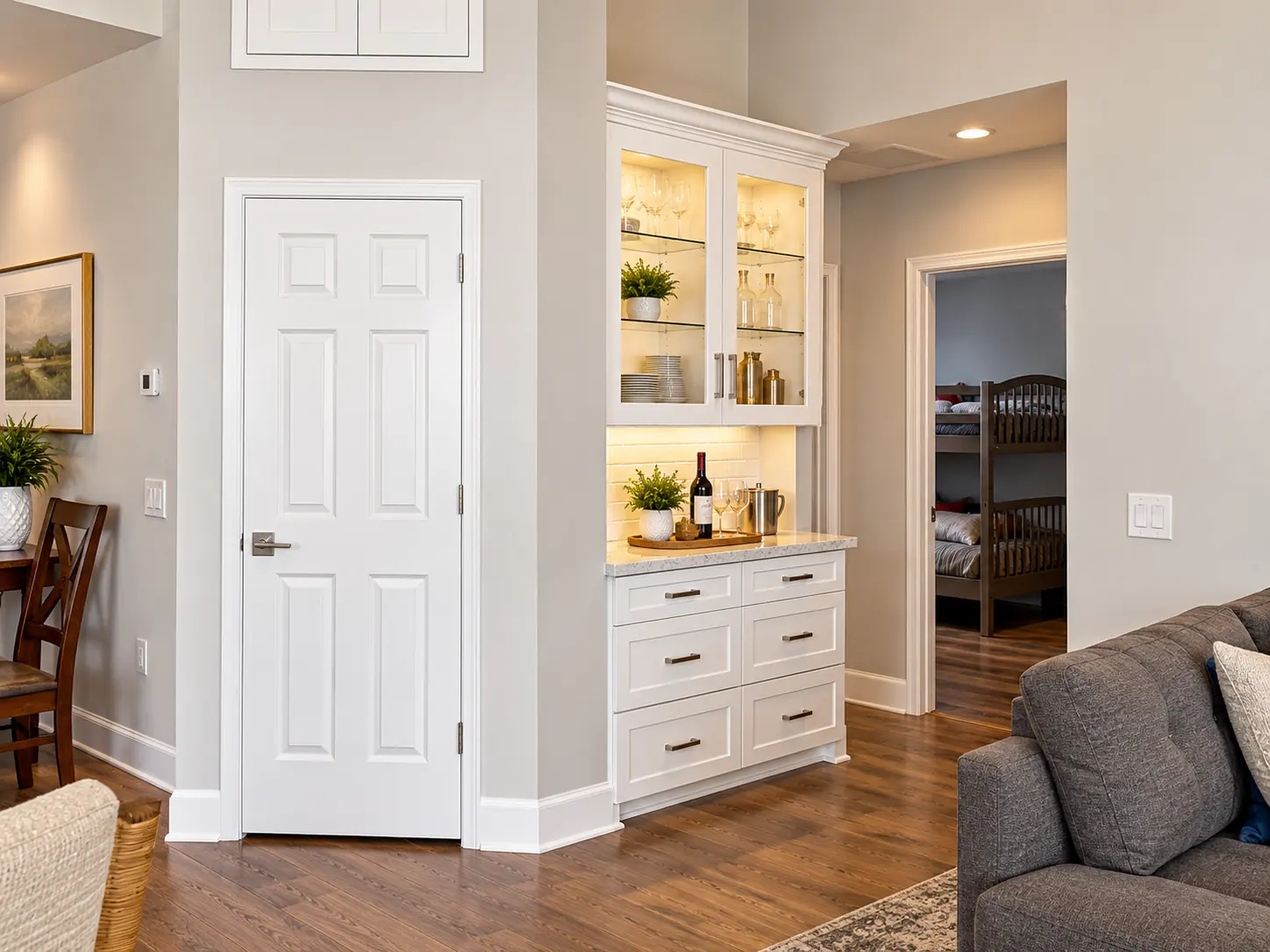 White hutch with glass uppers and drawers beside a doorway
