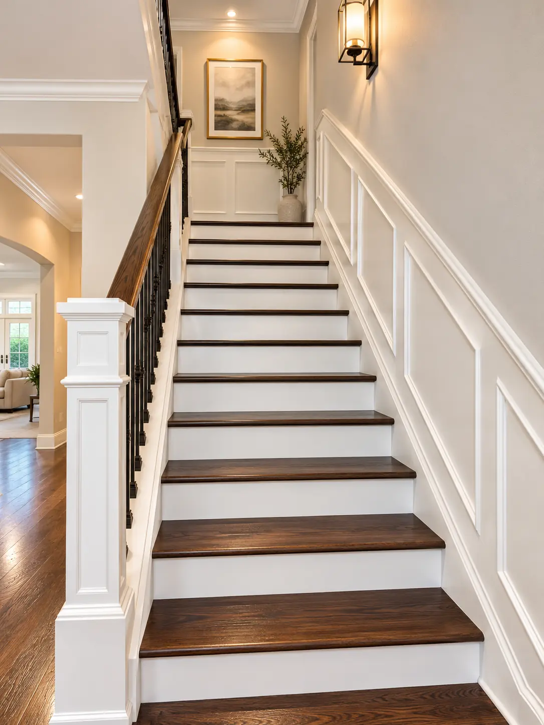 Staircase with full height white wainscoting panels