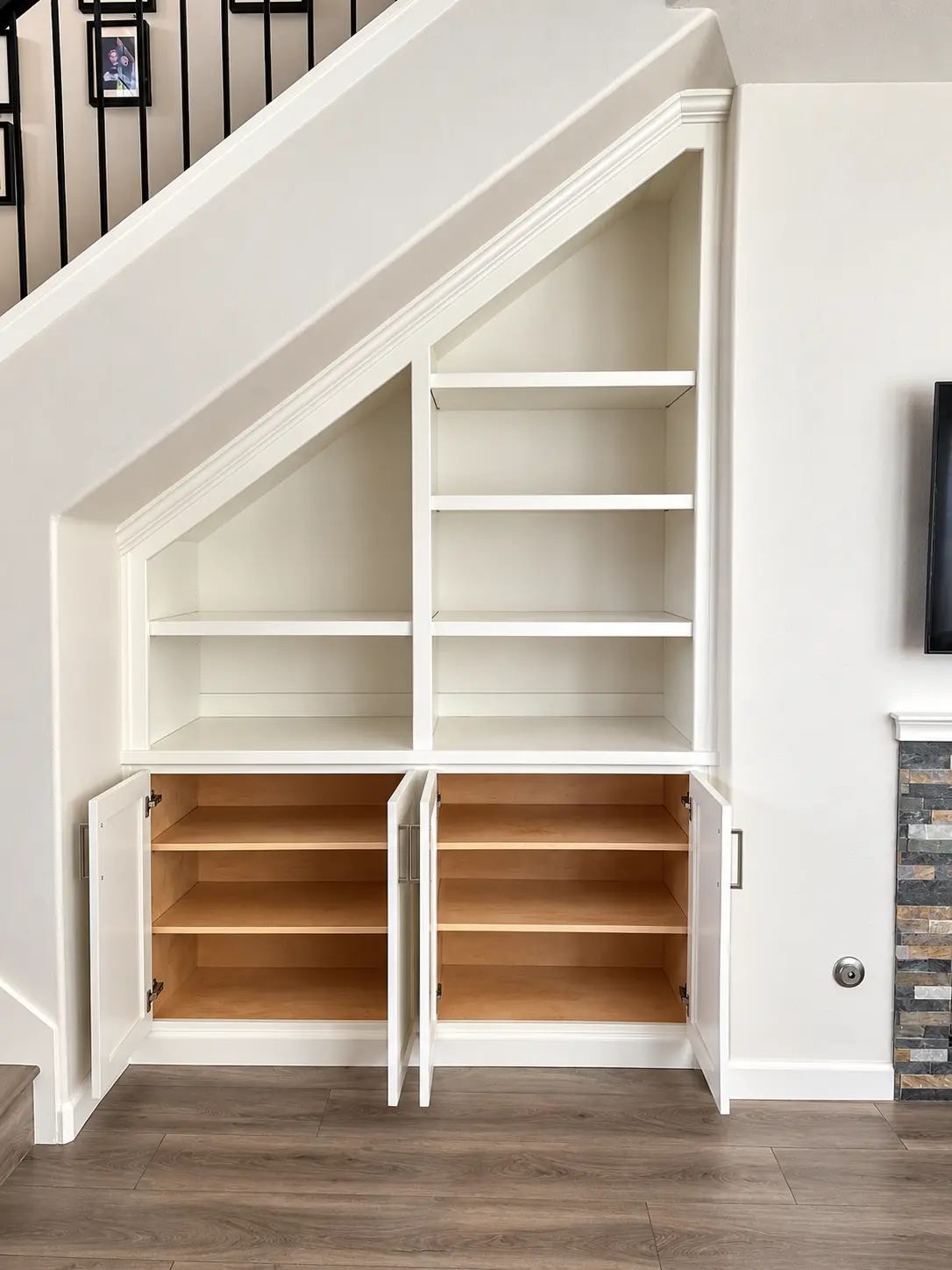 White under stair cabinet with oak lined cubbies and drawers