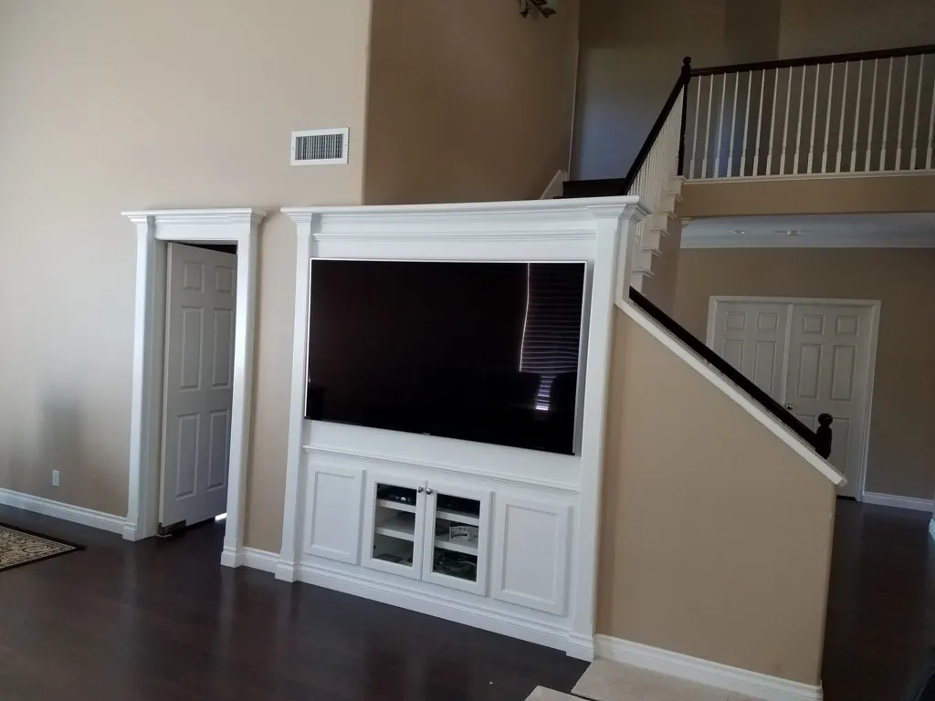 White entertainment center built under a staircase