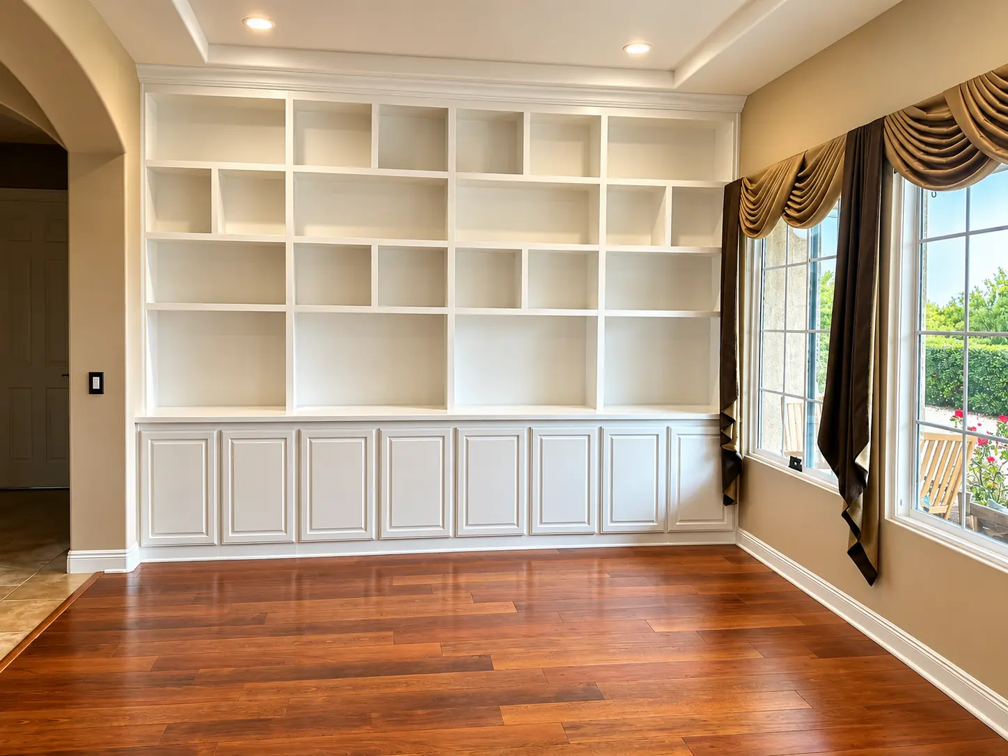 White built in bookcase wall with open cubbies above paneled cabinets