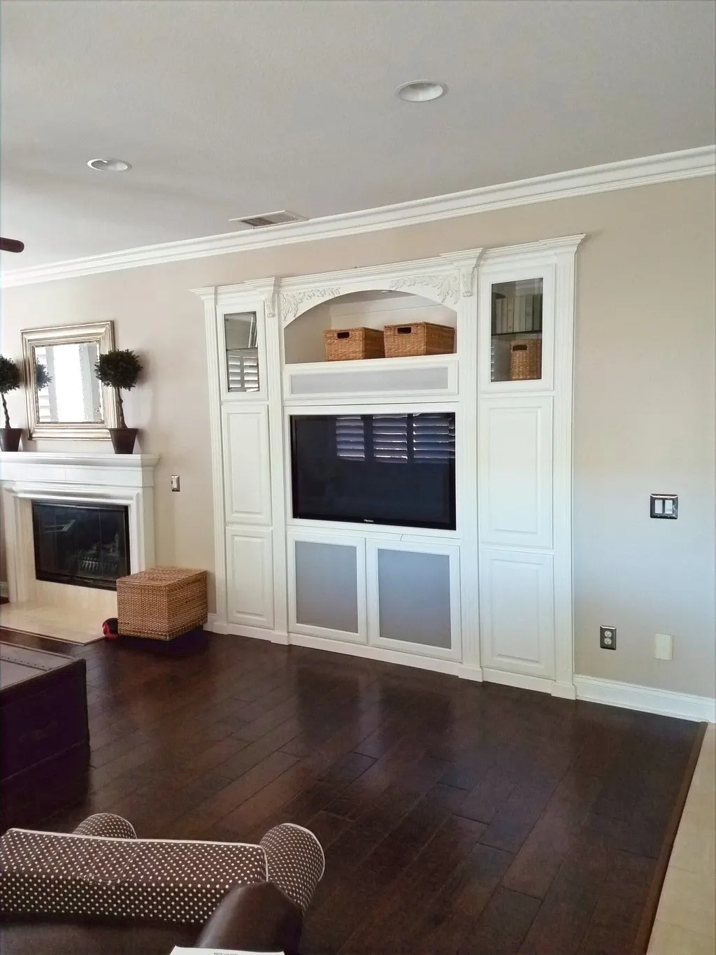 White built in media wall with a fireplace and an arched top